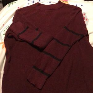 Maroon sweater with Four navy stripes on sleeves.